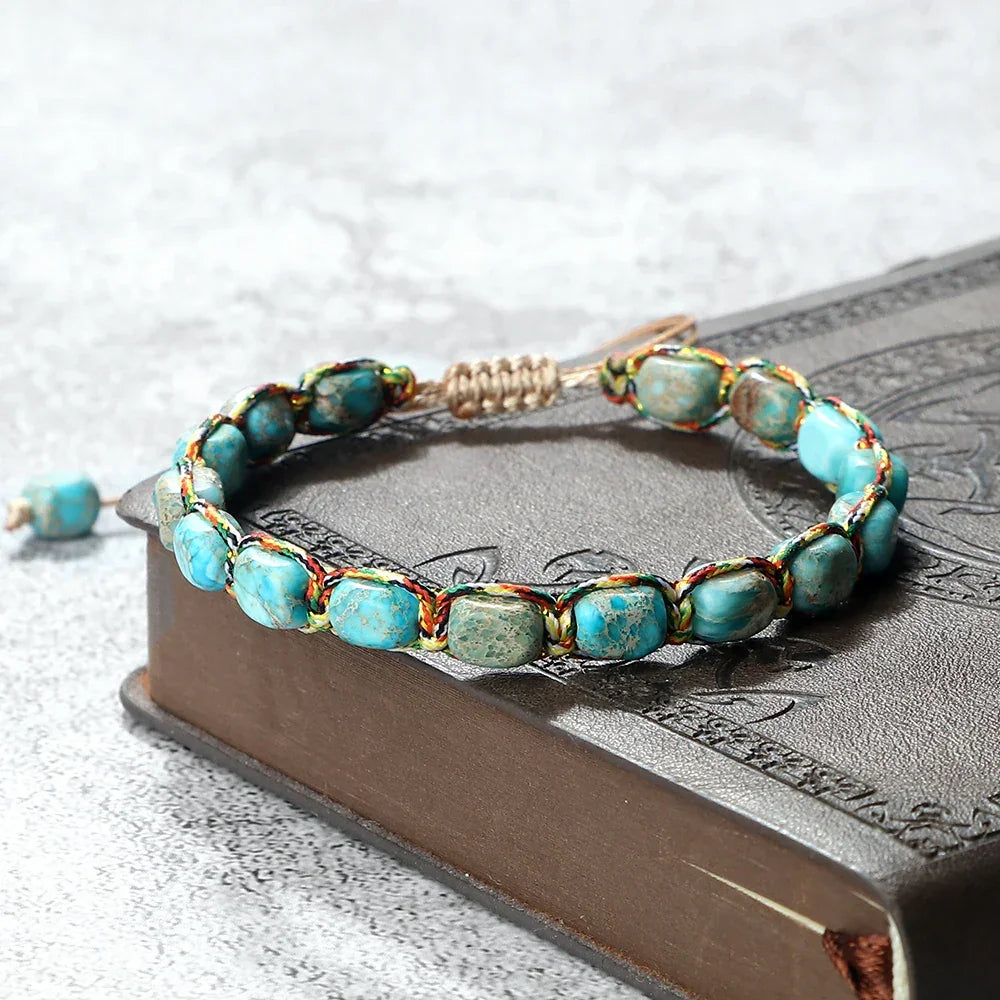 Turquoise stone beaded bracelet with multicolor thread on a brown embossed book