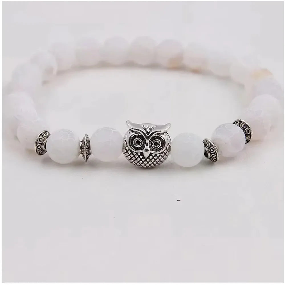 White beaded bracelet with central silver owl charm and decorative silver spacers