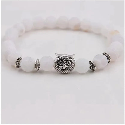 White beaded bracelet with central silver owl charm and decorative silver spacers