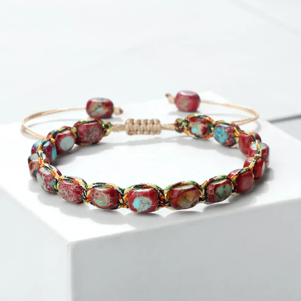 Adjustable bracelet with red and turquoise stone beads on a white platform
