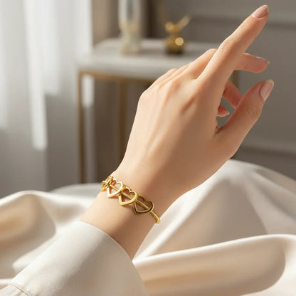 Close-up of female hand wearing elegant gold bracelet with heart-shaped links on wrist