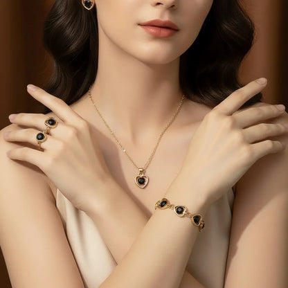 Woman wearing gold jewelry set with black heart-shaped stones including earrings, rings, necklace, and bracelet