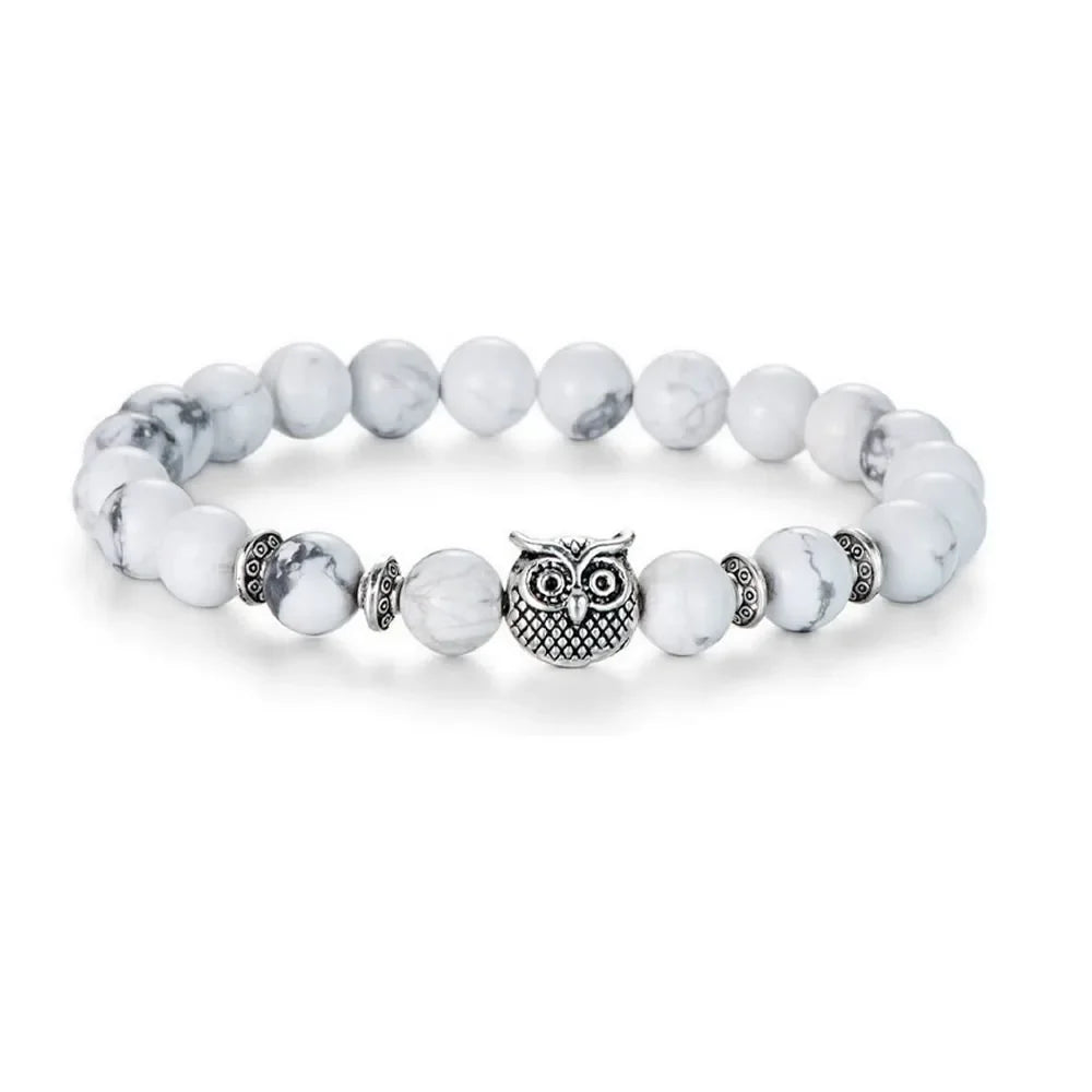 White marble bead bracelet with silver owl charm and decorative spacers on white background