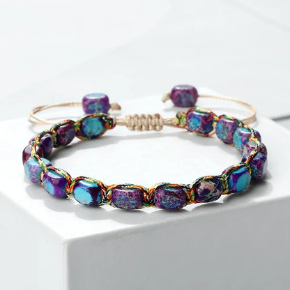 Adjustable bracelet with purple and turquoise beads on white surface
